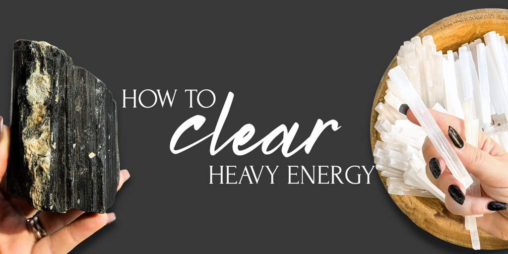 Hand holding Black Tourmaline and Selenite sticks with text “How to Clear Heavy Energy” on a dark background.