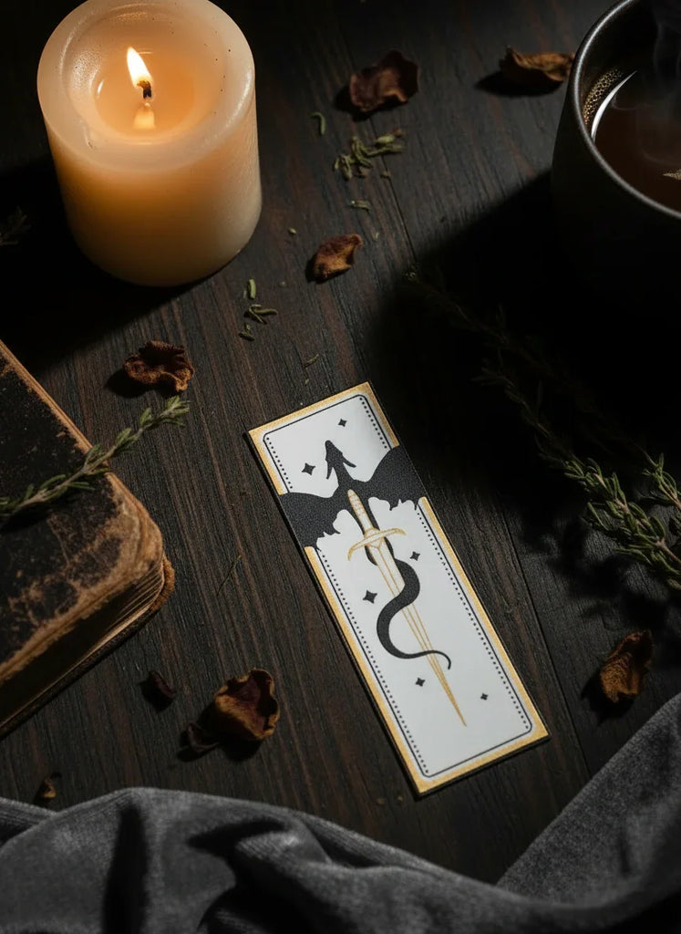 Candle, tarot card, and dried leaves on a dark surface