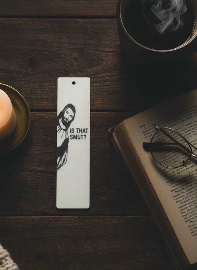 Bookmark with a design and text on a wooden surface with a book and glasses.
