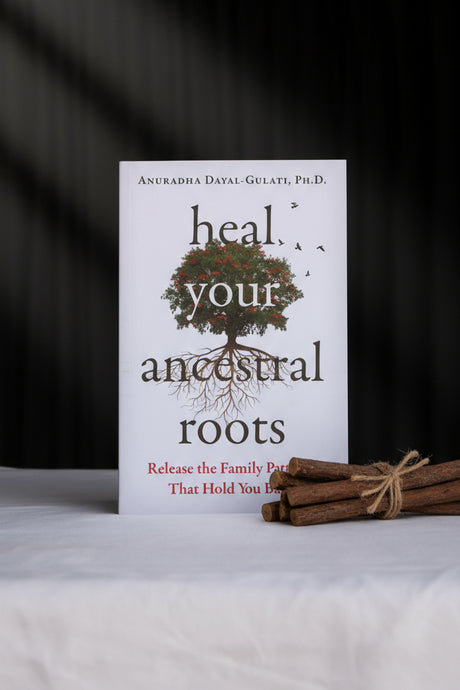 Book titled 'Heal Your Ancestral Roots' on a white surface with a black background