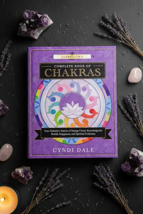 The front cover of the book 'Complete Book of Chakras' by Cyndi Dale, featuring a purple background with a colorful chakra wheel illustration and gold lettering.