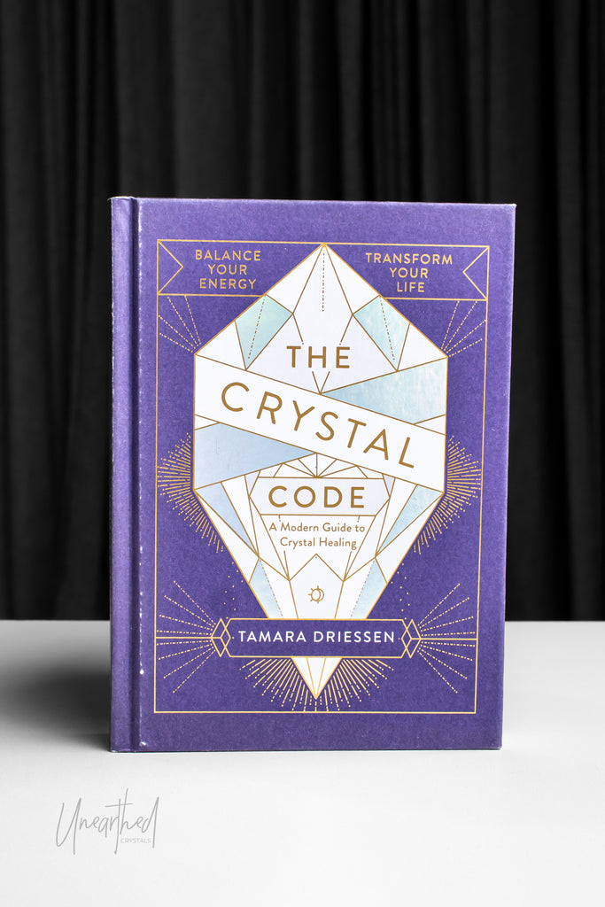 Book titled 'The Crystal Code' by Tamara Driessen on a dark background