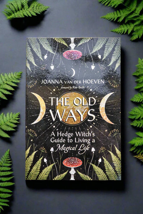 Book titled 'The Old Ways' by Joanna van der Hoeven surrounded by green foliage on a dark background