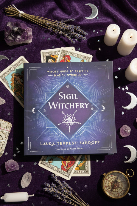 Book titled 'Sigil Witchery' by Laura Tempest Zakroff on a purple velvet background.