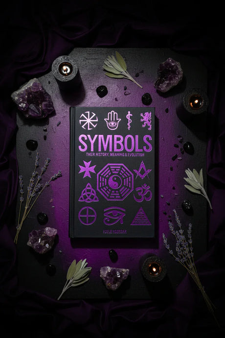Book titled 'Symbols' with mystical symbols on a dark background with crystals and plants.