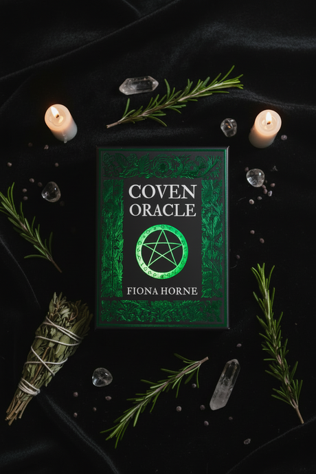 Coven Oracle book by Fiona Horne on a dark background with candles and herbs