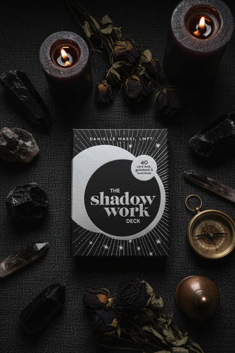 The Shadow Work Deck by Danielle Maist on a dark surface with candles and crystals.