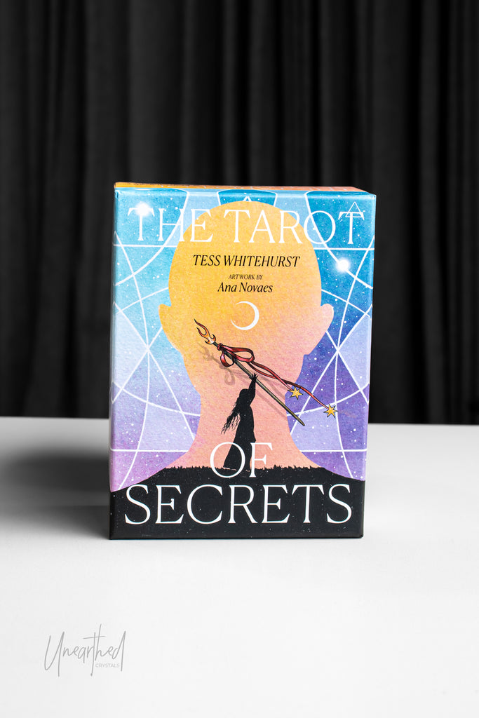Book titled 'The Tarot of Secrets' by Tess Whitehurst and Ana Novas on a black background