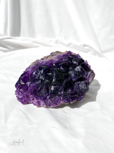 Purple Fluorite crystal on a white background
