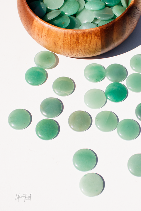 Green Aventurine stones in a wooden bowl on a white background