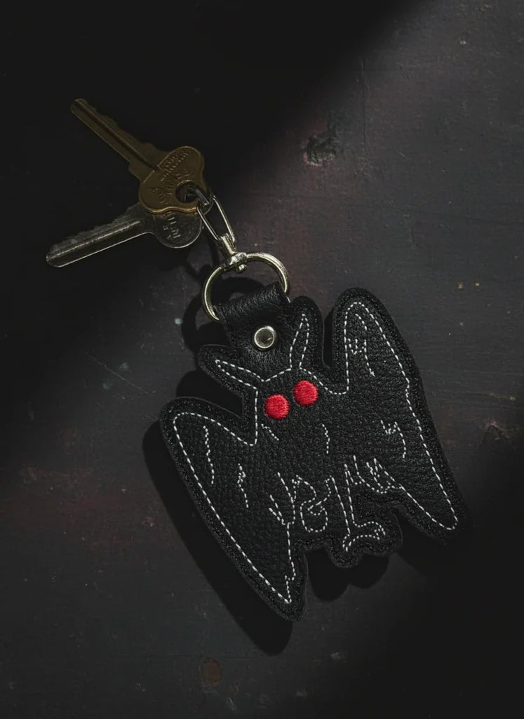 Keychain with a black bat design and red heart on a white background