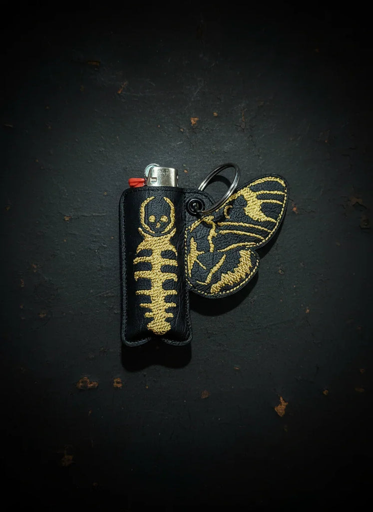 Lighter case with skeleton design on a dark surface
