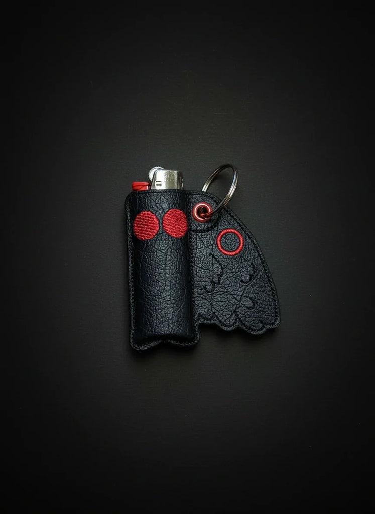 Black leather lighter case with red accents on a black background