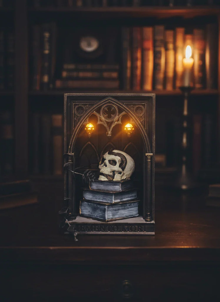 Decorative skull and books in a gothic frame with candlelight in a bookshelf setting