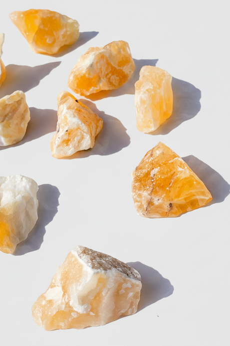 Raw Orange Calcite stones on a white background