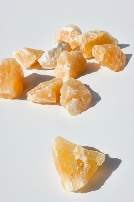Orange Calcite pieces on a white background