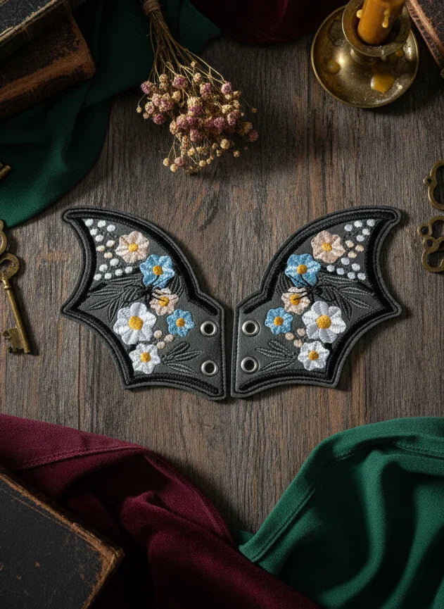 Decorative leather patch with floral design on a wooden surface with books and keys.