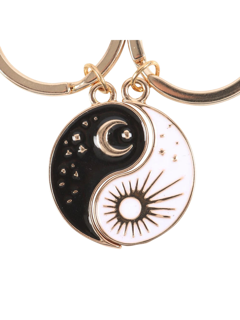Keychain with yin yang design featuring a moon and sun on a white background