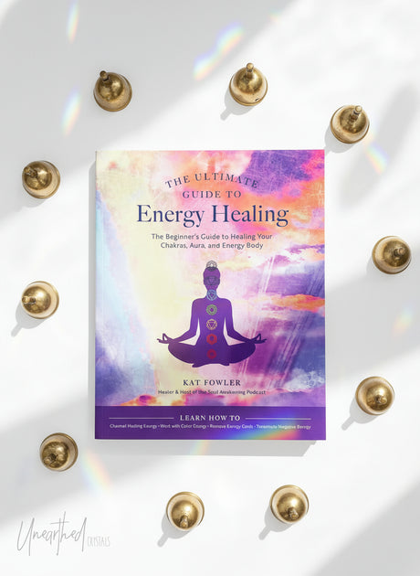 Book cover of 'The Ultimate Guide to Energy Healing' with a colorful design and silhouette of a person in meditation.
