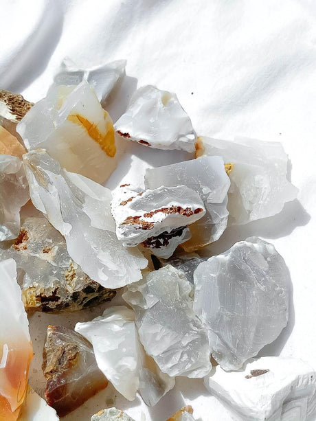Close-up of white and beige agate crystal rocks on a white background