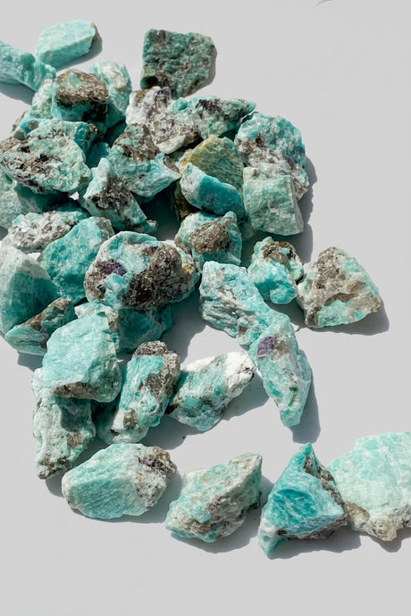 Amazonite raw gemstones on a light gray background