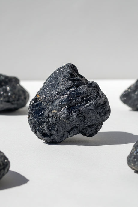 Black Tourmaline on a white surface with a gray background